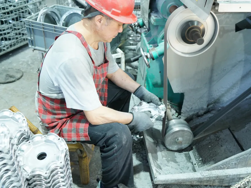 Worker polishing and grinding die-cast aluminum LED housings at Sunjoylight factory