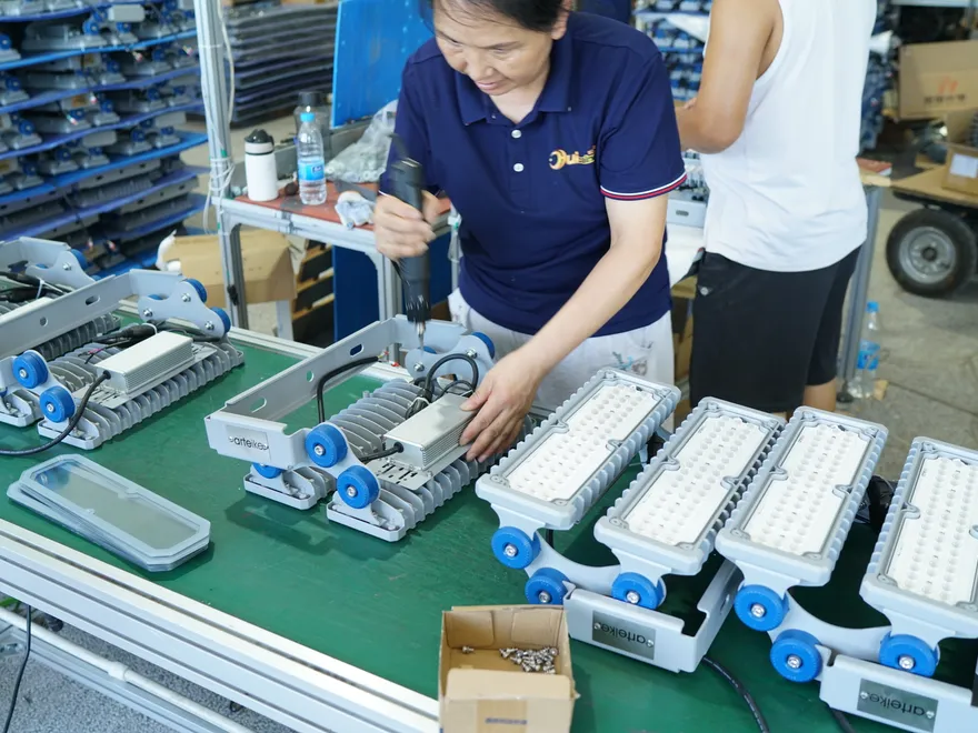 Workers assembling LED flood lights on the Sunjoylight production line