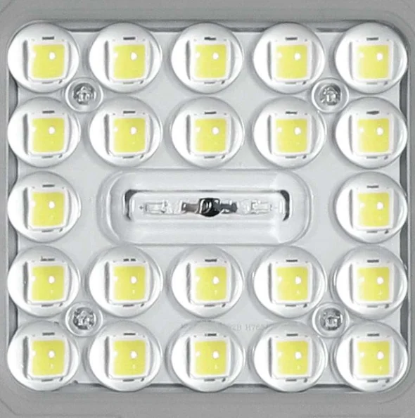 Close-up of an LED flood light optical module — a grid of clear polycarbonate lens cups over the SMD LED chips, with the beam-shaping lenses concentrating light from each LED