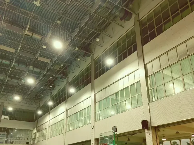 Indoor multi-purpose court lit by LED high bay fixtures, with daylight from the clerestory windows along both walls